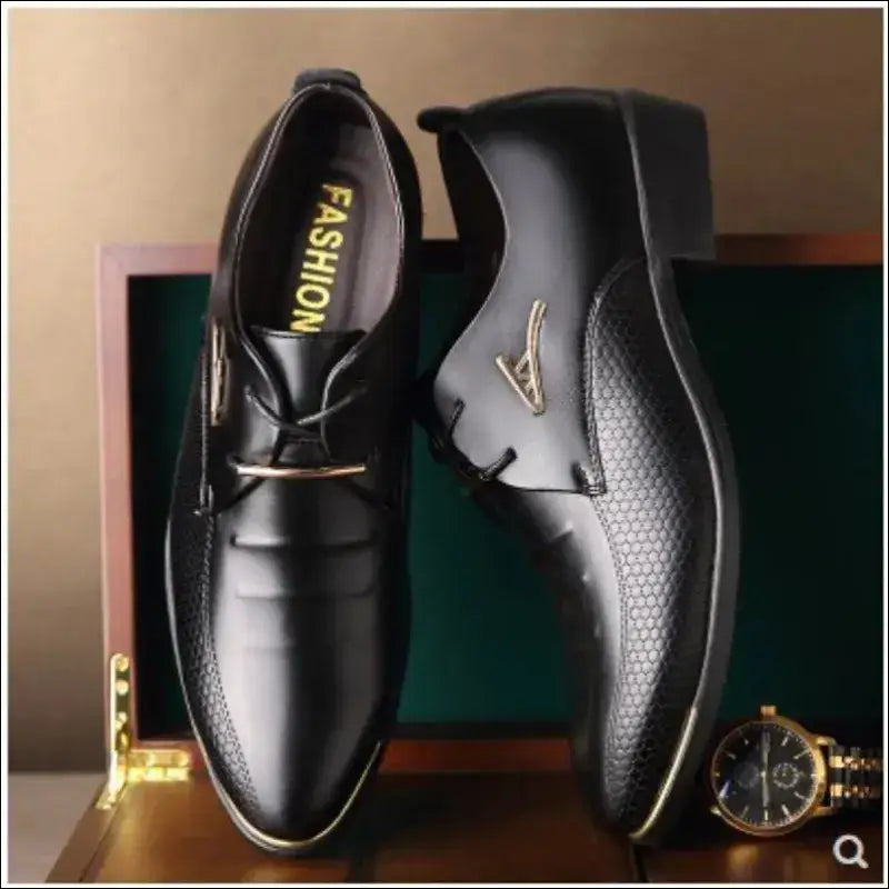 Pair of black leather dress shoes with perforated detailing.