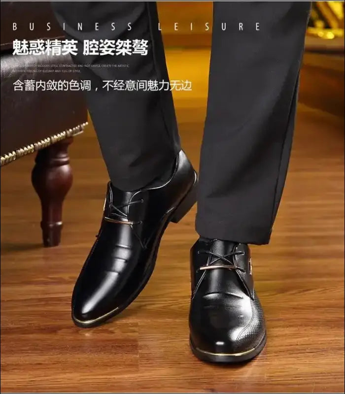 Pair of shiny black leather dress shoes with laces, worn with dark trousers.