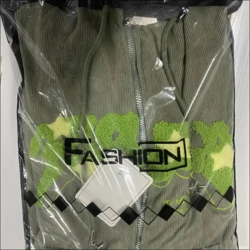 Packaged green sweater or sweatshirt with a geometric pattern visible through clear plastic packaging.