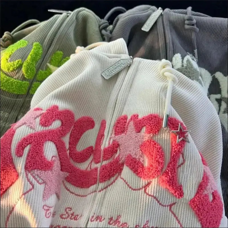 Pile of light-colored clothing or fabric items with visible logos and text.