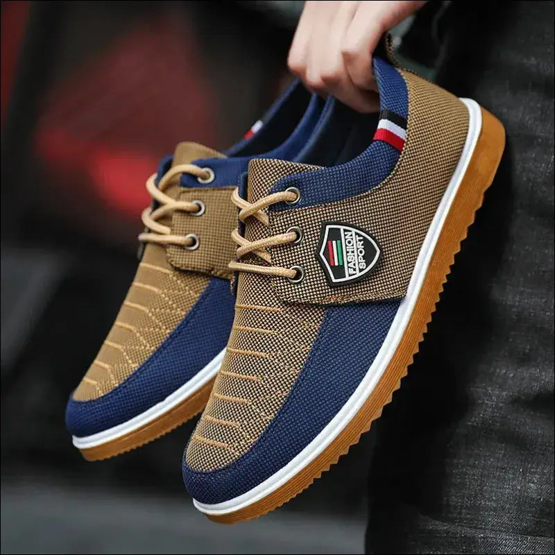 Casual sneaker with blue and tan color-blocking, featuring a distinctive patch logo on the side.