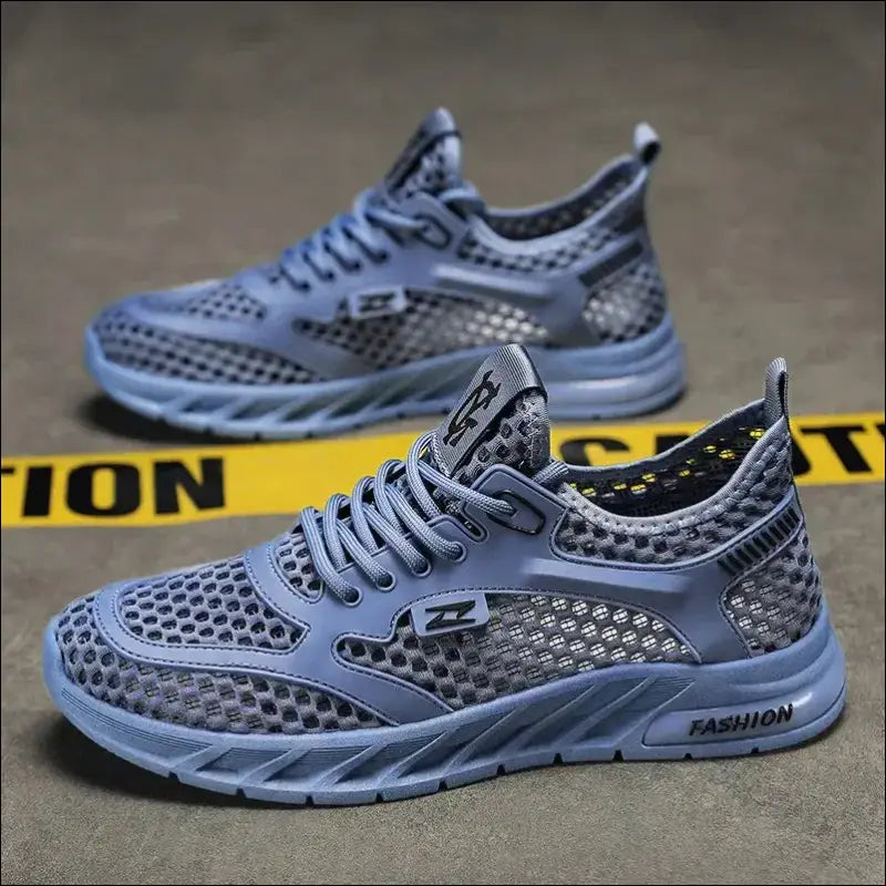 Pair of light blue athletic sneakers with mesh detailing and ’FASHION’ printed on the side.