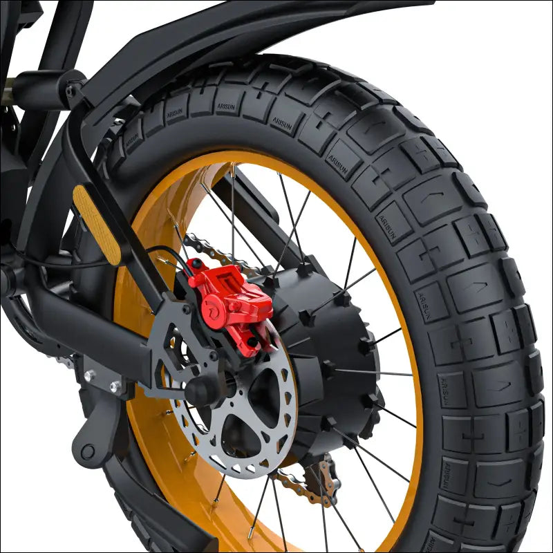 Motorcycle wheel with a thick tire, gold rim, and red disc brake caliper.