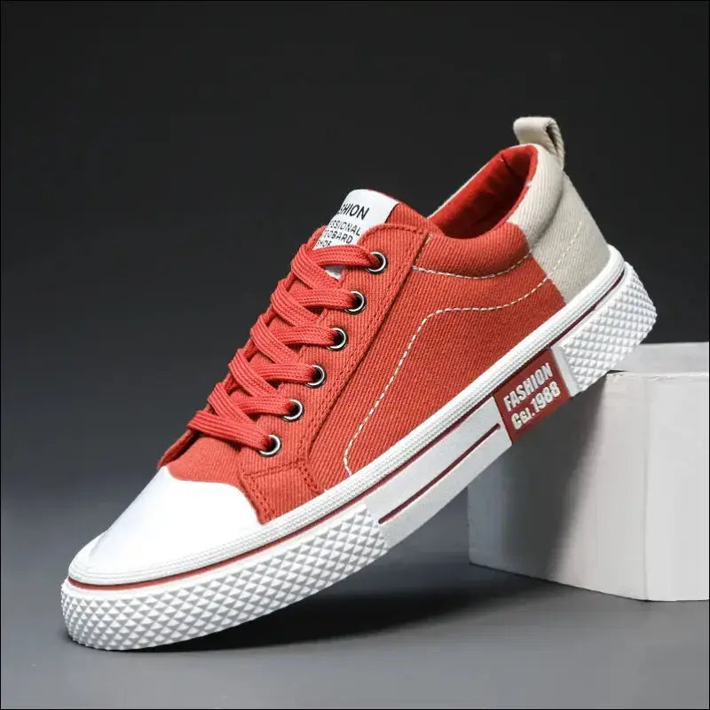 Red and white canvas sneaker with laces and a rubber sole.