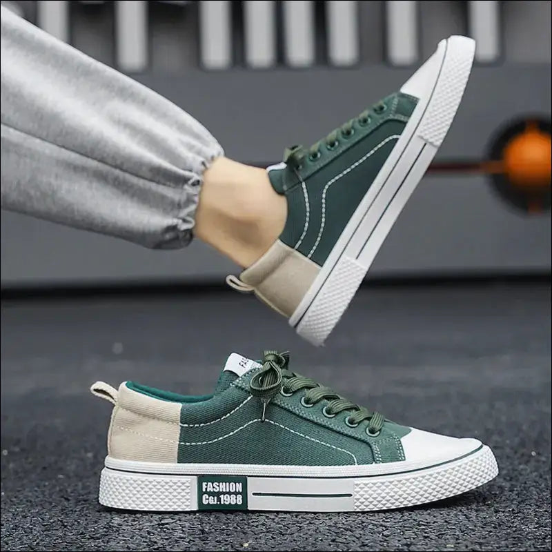 Green and white casual sneaker with laces and a contrasting heel patch.