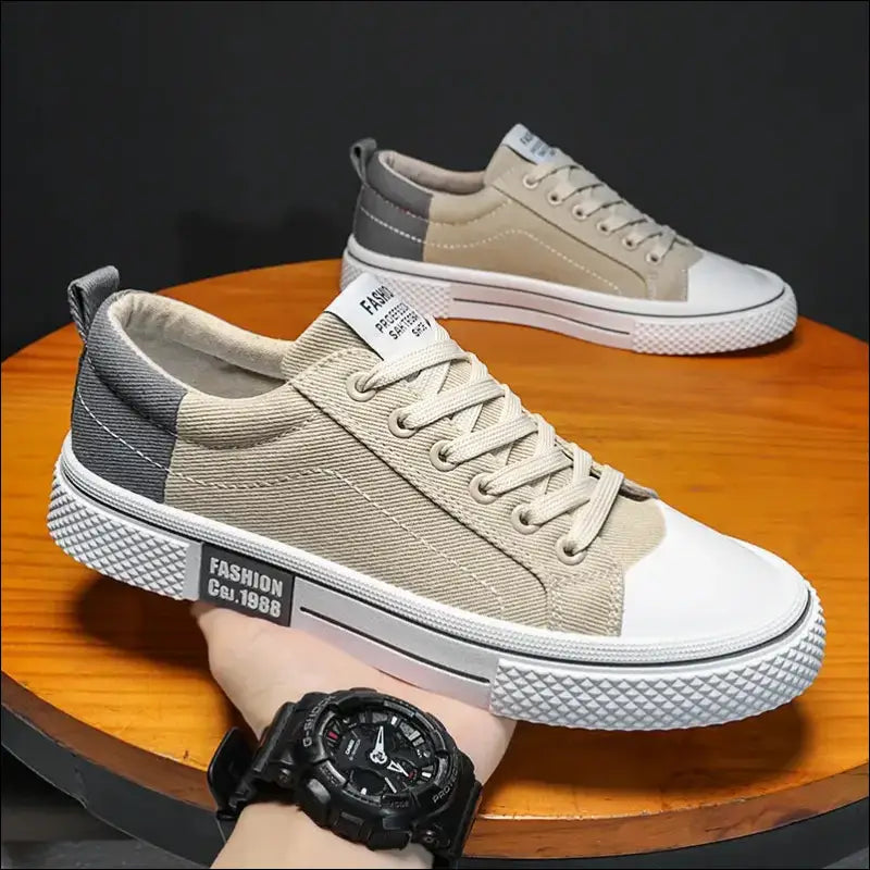 Pair of beige canvas sneakers with white rubber soles and toe caps.