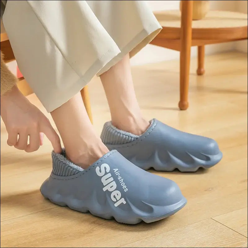 Pair of gray slip-on shoes with a wavy, oversized sole design and ’Super’ branding.