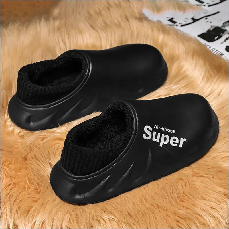 Pair of black slip-on clogs with ’Super’ printed on the side.