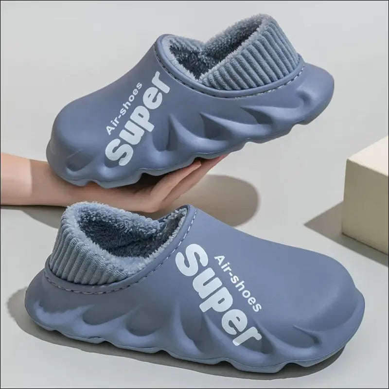 Pair of gray foam slip-on shoes with ribbed ankle collars and ’Super’ branding.