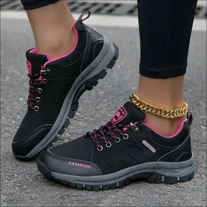 Black and pink athletic sneaker with a chunky sole and gold ankle bracelet.