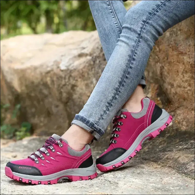 Pink and gray hiking or trail running shoe with a rugged sole.